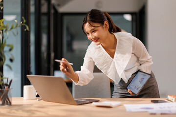 Portrait of business Asian woman Accounting using tablet calculating income-expenditure and...