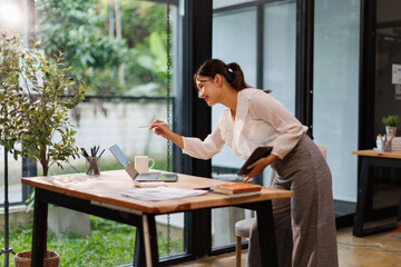 Portrait of business Asian woman Accounting using tablet calculating income-expenditure and...