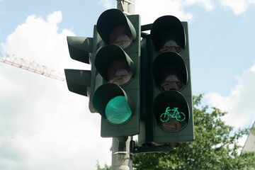Green traffic lights for cars and bicycles under sunny sky
