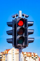 Red traffic light for vehicles under clear blue sky