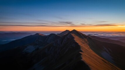 Breathtaking mountain ridge at sunset with dramatic lighting and distant clouds - Powered by Adobe