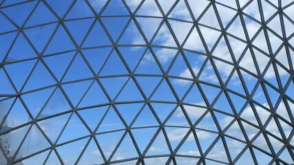 Large, clear dome with a blue sky above it. The dome is made of many small, triangular pieces of glass - Powered by Adobe