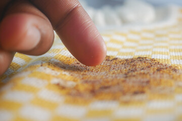 Person examining stain on cloth surface