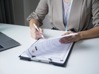 Asian businesswoman employer sitting holding new employee's documents to evaluate and review new...