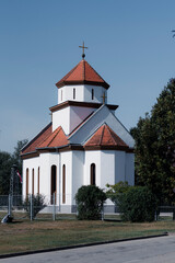 Fototapeta premium Small white Orthodox church with red tiled roof