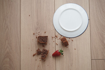 Crumbled cake with strawberry spilled wooden floor