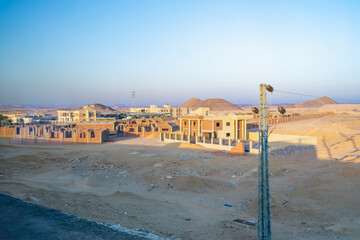 A picturesque view of Aswan's desert landscape featuring modern construction projects, captured at dawn during a bus journey to Abu Simbel Temples.