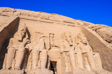 Close up of the majestic Great Temple of Ramses II at Abu Simbel, Aswan, Egypt. The colossal seated statues of Pharaoh Ramses II dominate this iconic ancient Egyptian monument.