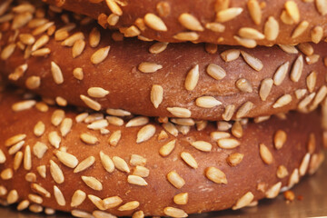 Freshly baked sesame bread rolls stacked in a bakery