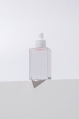Minimal Dropper Bottle with Pink Serum on White Background