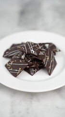 Crispy brownies arranged on a glass jar and white ceramic plate with a white marble background. isolate objects and background