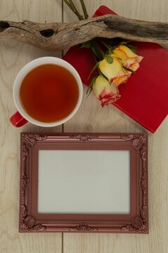 Fototapeta Photo frame, lemon tea, diary and flowers on wooden table