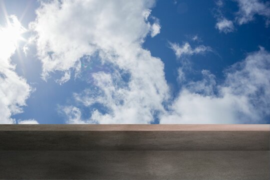Fototapeta Flat design rooftop is showing concrete ledge under sky with white clouds and sunlight glare