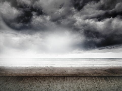 Fototapeta Boardwalk is extending over wet sand toward calm sea under brooding storm clouds in flat design