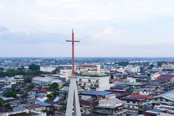 Skyline of Pontianak city reflecting its ethnic and religious diversity, marked by a church steeple...