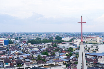 Skyline of Pontianak city reflecting its ethnic and religious diversity, marked by a church steeple...