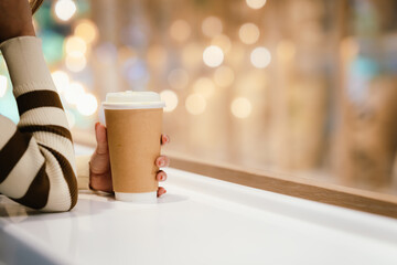 A young woman wearing headphones and glasses, appearing to be an East Asian female, intently uses a white laptop at a cafe table.