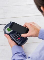 Man holding credit card reader and mobile phone
