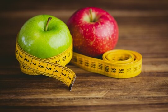 Fototapeta Red and green apples with measuring tape