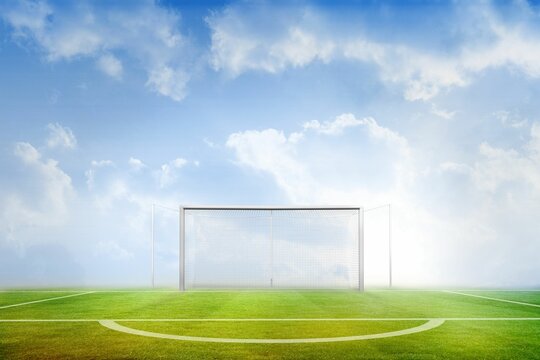 Football pitch under blue sky - Powered by Adobe