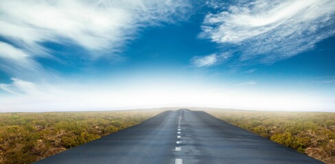 Flat design is showing paved road with dashed center line stretching through shrubs under blue sky