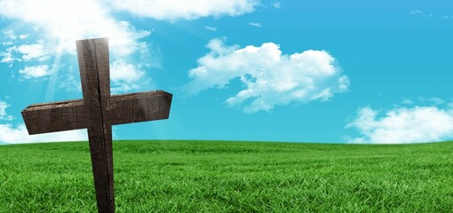 Flat design is showing wooden cross rising in green meadow under blue sky with sun rays