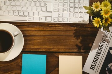 Directly above view of keyboard and coffee cup with newspaper