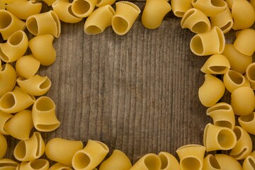 Raw pasta on wooden table