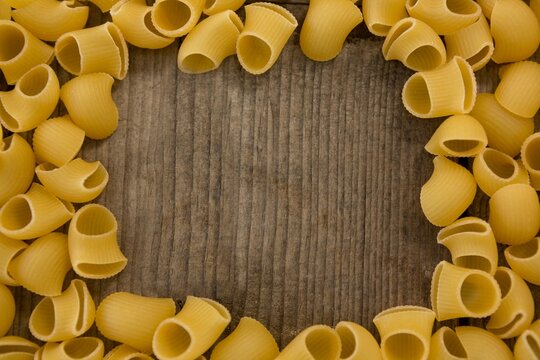 Raw pasta on wooden table