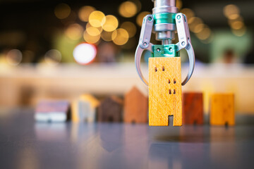 AI in real estate: A robotic arm lifts a tiny wooden house, showcasing technology's power to match...