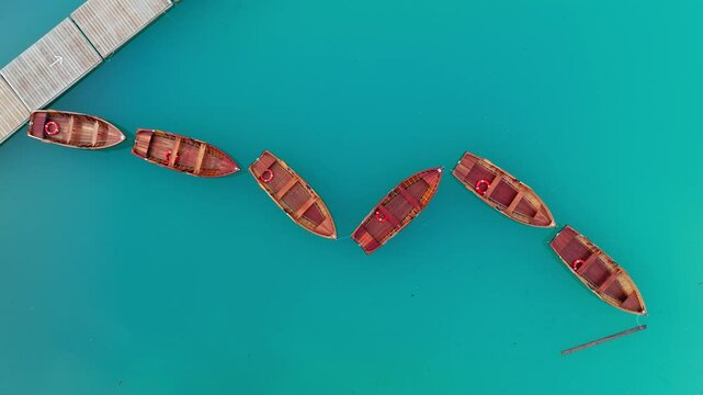 Lago di Braies or Lake Braies crystal blue lake with wooden rowing boats in Italian Dolomites, Overhead drone shot