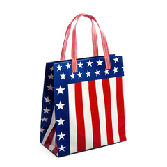 Fototapeta premium A patriotic American flag-themed gift bag with red, white, and blue colors and stars on a white background.