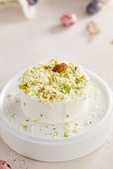 Curd paskha with pistachios, bright natural lighting, overhead minimalist composition