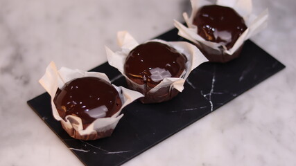 chocolate cake wrapped in cake paper with chocolate glaze topping
