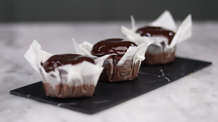 chocolate cake wrapped in cake paper with chocolate glaze topping