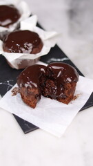 chocolate cake wrapped in cake paper with chocolate glaze topping