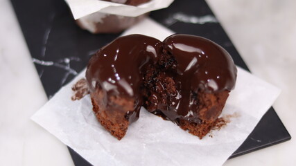 chocolate cake wrapped in cake paper with chocolate glaze topping