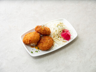 croquettes and cabbage salad on a plate