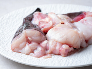 Raw monkfish cut into pieces on a plate
