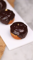 three cakes with frosted and gold chocolate topping and crunchy chocolate filling