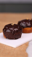 three cakes with frosted and gold chocolate topping and crunchy chocolate filling