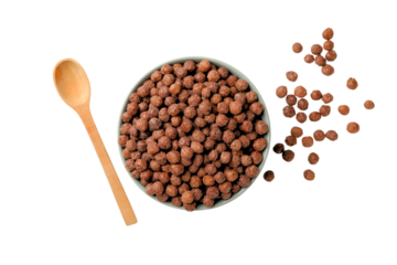 Chocolate cereal in bowl with spoon nearby, isolated on white, PNG