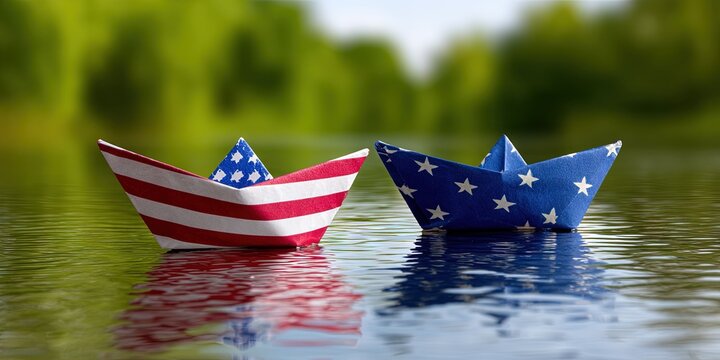 two paper boats in the water. One is made of american flag paper. One is made of EU flag paper - Powered by Adobe