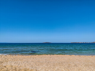 Beach, sea, empty sky and island in the distance