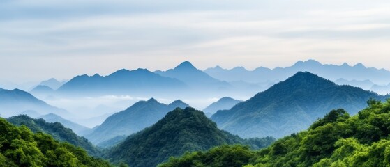 Serene Mountain Landscape with Mist and Lush Greenery Under a Soft Blue Sky