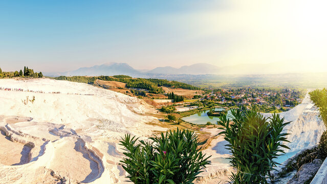 Panoramic view of the stunning white travertine terraces and thermal pools of Pamukkale, a famous UNESCO World Heritage Site and popular tourist travel destination in Denizli, Turkey - Powered by Adobe