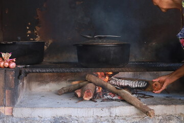 Cuisson traditionnelle au feu de bois avec marmite en fonte