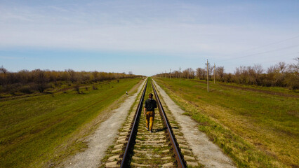 One man walks by railroad to the horizon