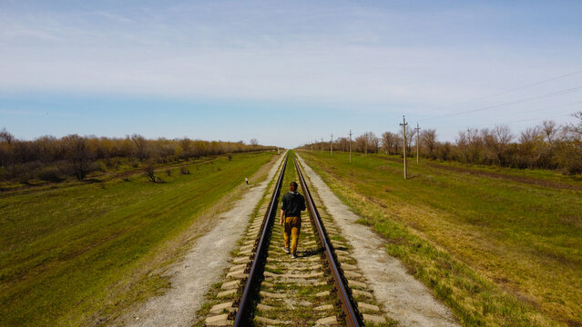 One man walks by railroad to the horizon