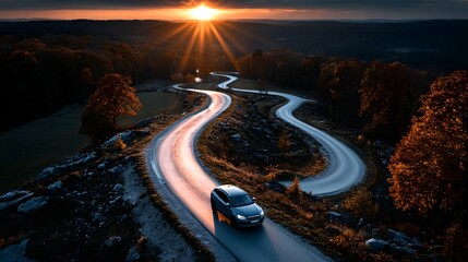 Auto fährt bei Sonnenuntergang auf spektakulärer Serpentinenstraße durch die Berge
